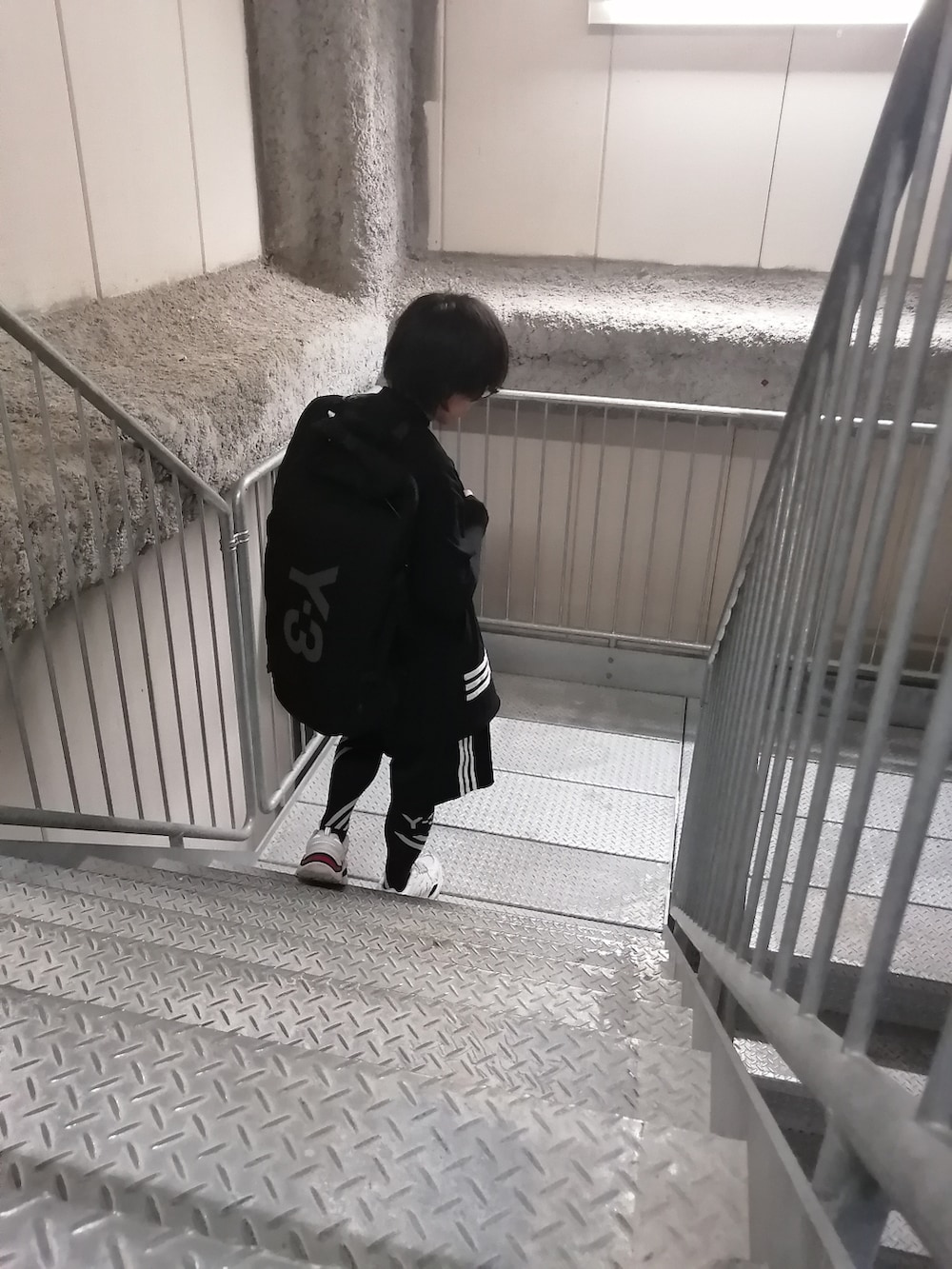 ブラック系のパンツ、ブラック系のTシャツ/カットソー、ブラック系のバックパック/リュックを着用したメンズの春コーディネートの2枚目の写真