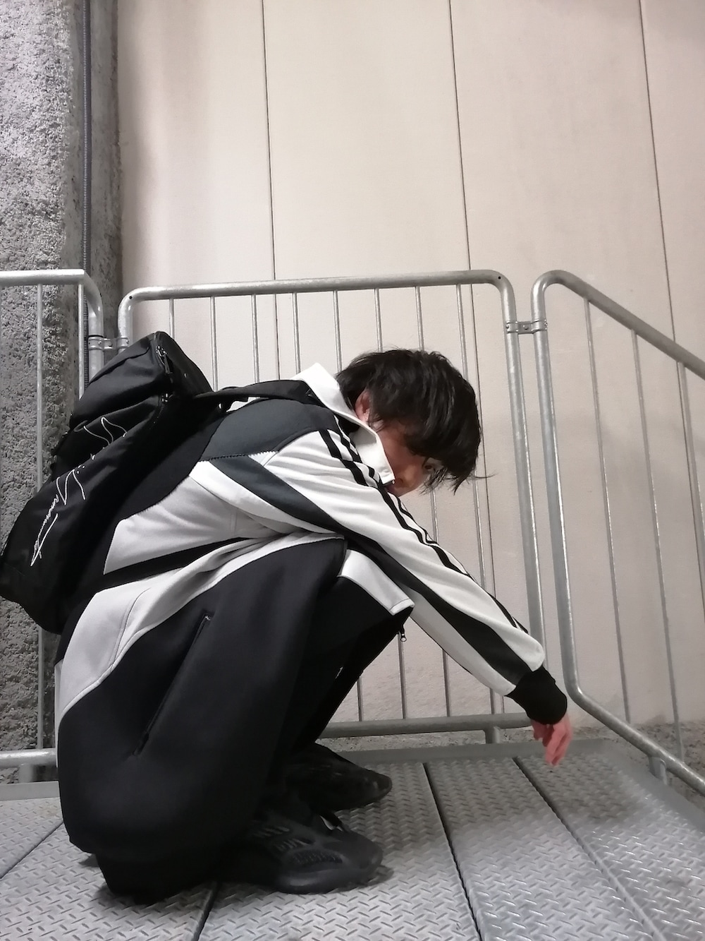 ブラック系のその他パンツ、ブラック系のスニーカー、ブラック系のバッグを着用したメンズの春コーディネートの3枚目の写真