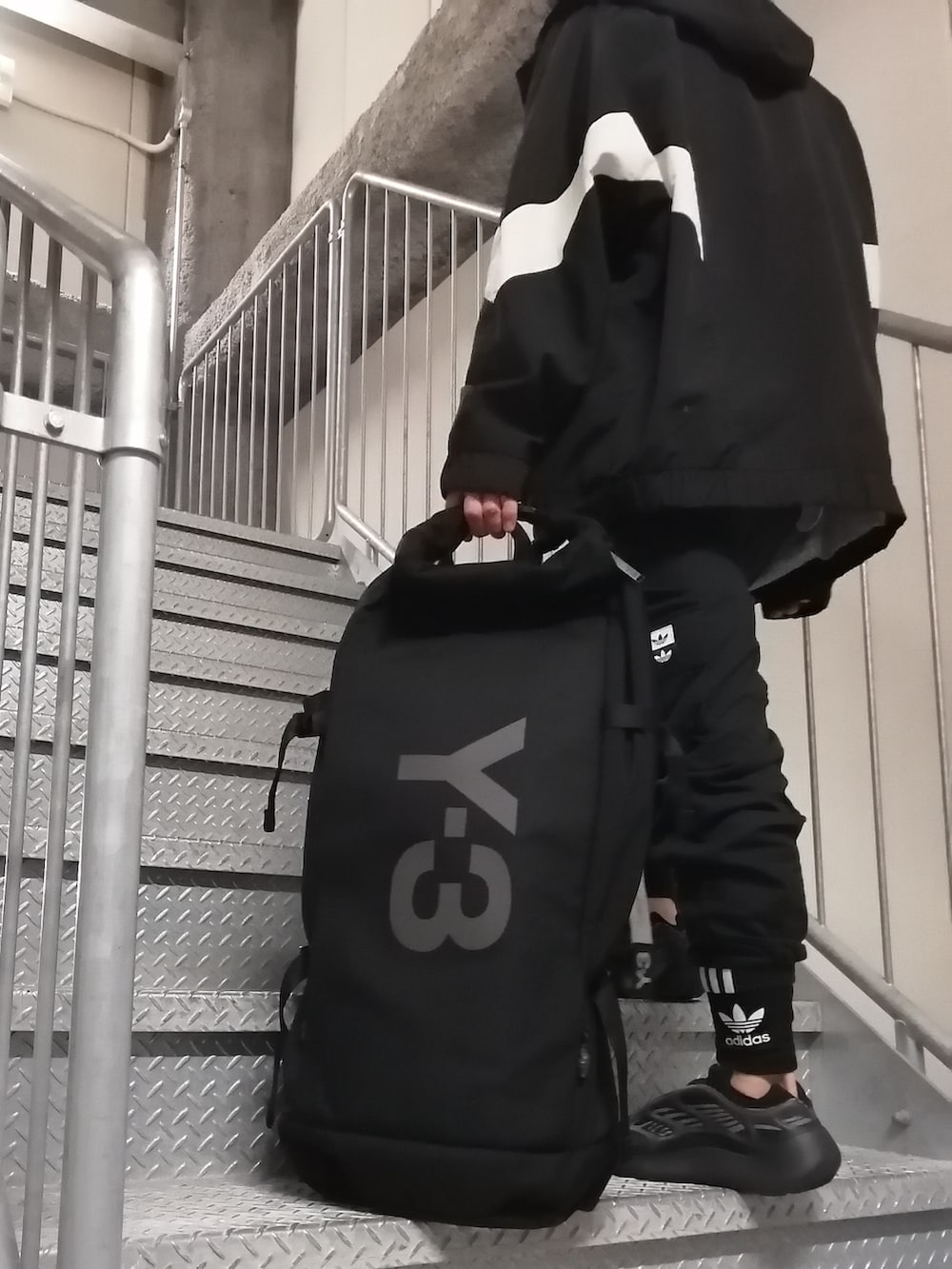 ブラック系のカーゴパンツ、ブラック系のスニーカー、ブラック系のバックパック/リュックを着用したメンズの春コーディネートの3枚目の写真