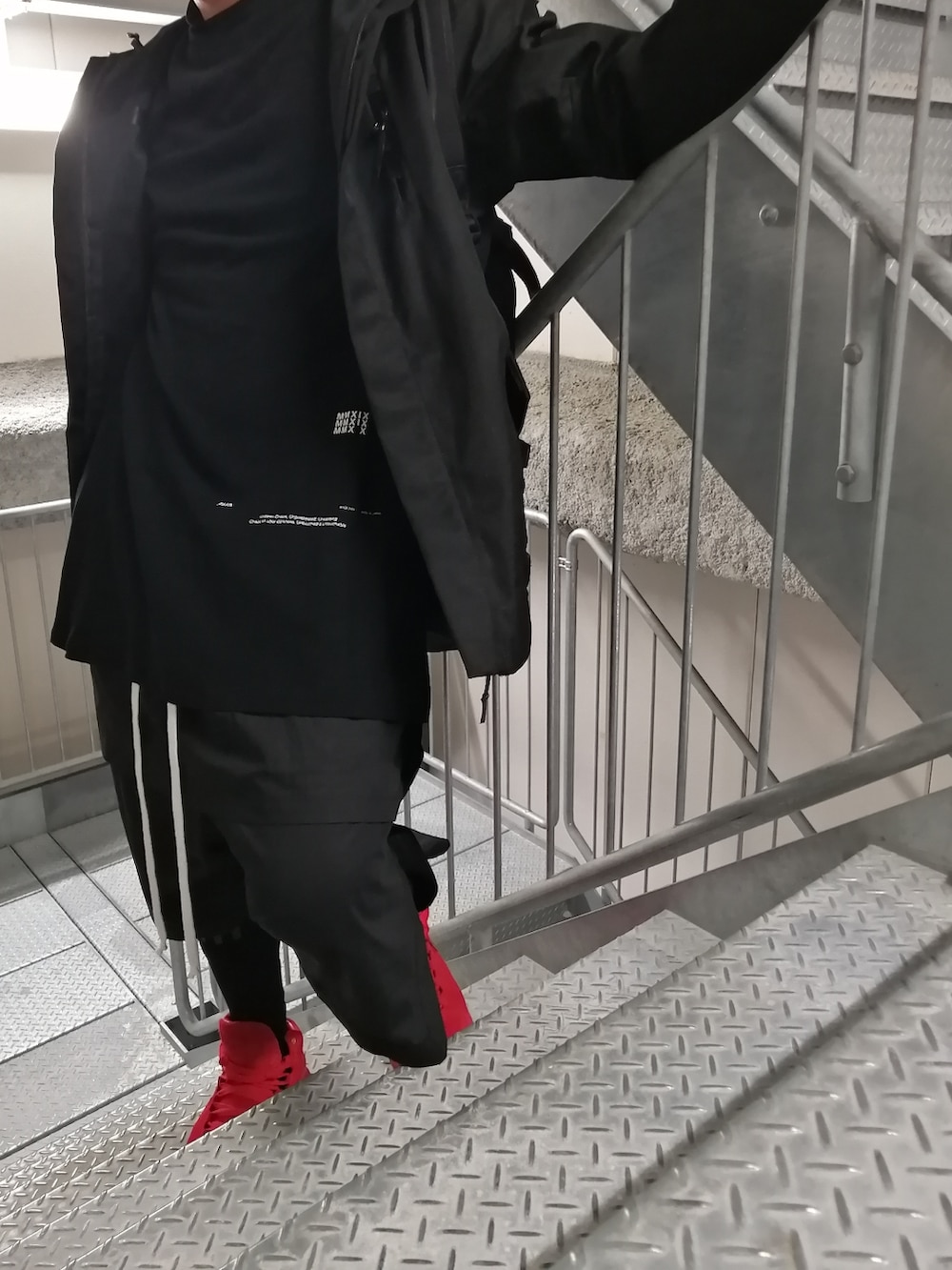 レッド系のスニーカー、ブラック系のパンツ、ブラック系のジャケット/アウターを着用したメンズの春コーディネートの3枚目の写真