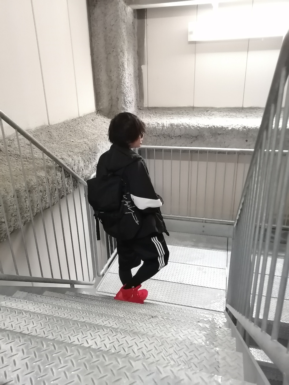 レッド系のスニーカー、ブラック系のパンツ、ブラック系のジャケット/アウターを着用したメンズの春コーディネートの2枚目の写真