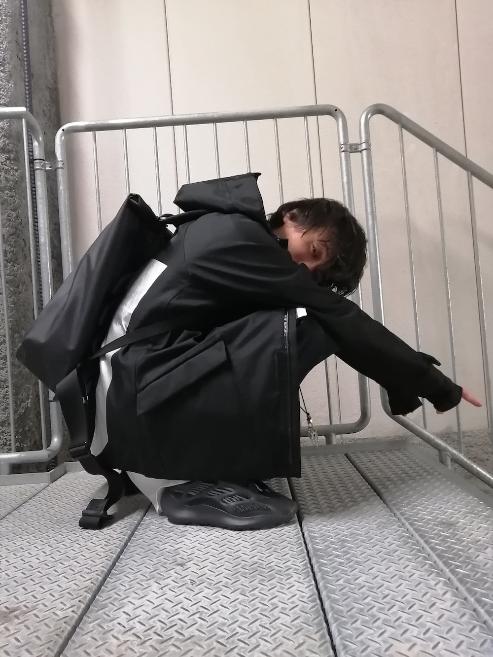 ブラック系のスニーカー、ブラック系のパンツ、ブラック系のバックパック/リュックを着用したメンズの春コーディネートの3枚目の写真