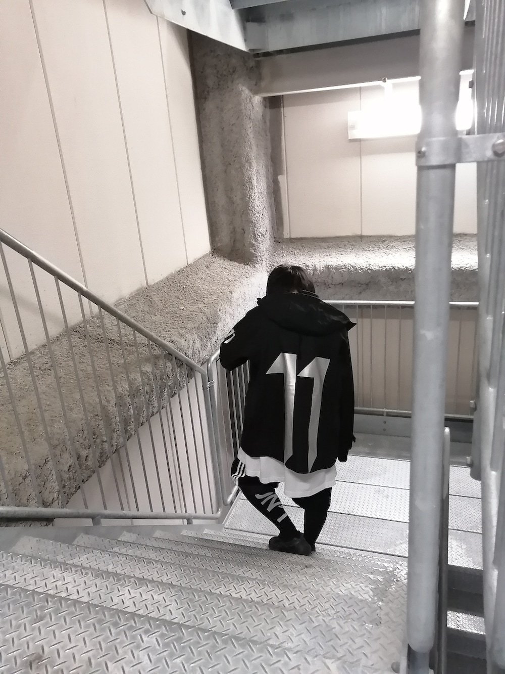 ブラック系のスニーカー、ブラック系のパンツ、ブラック系のバックパック/リュックを着用したメンズの春コーディネートの4枚目の写真