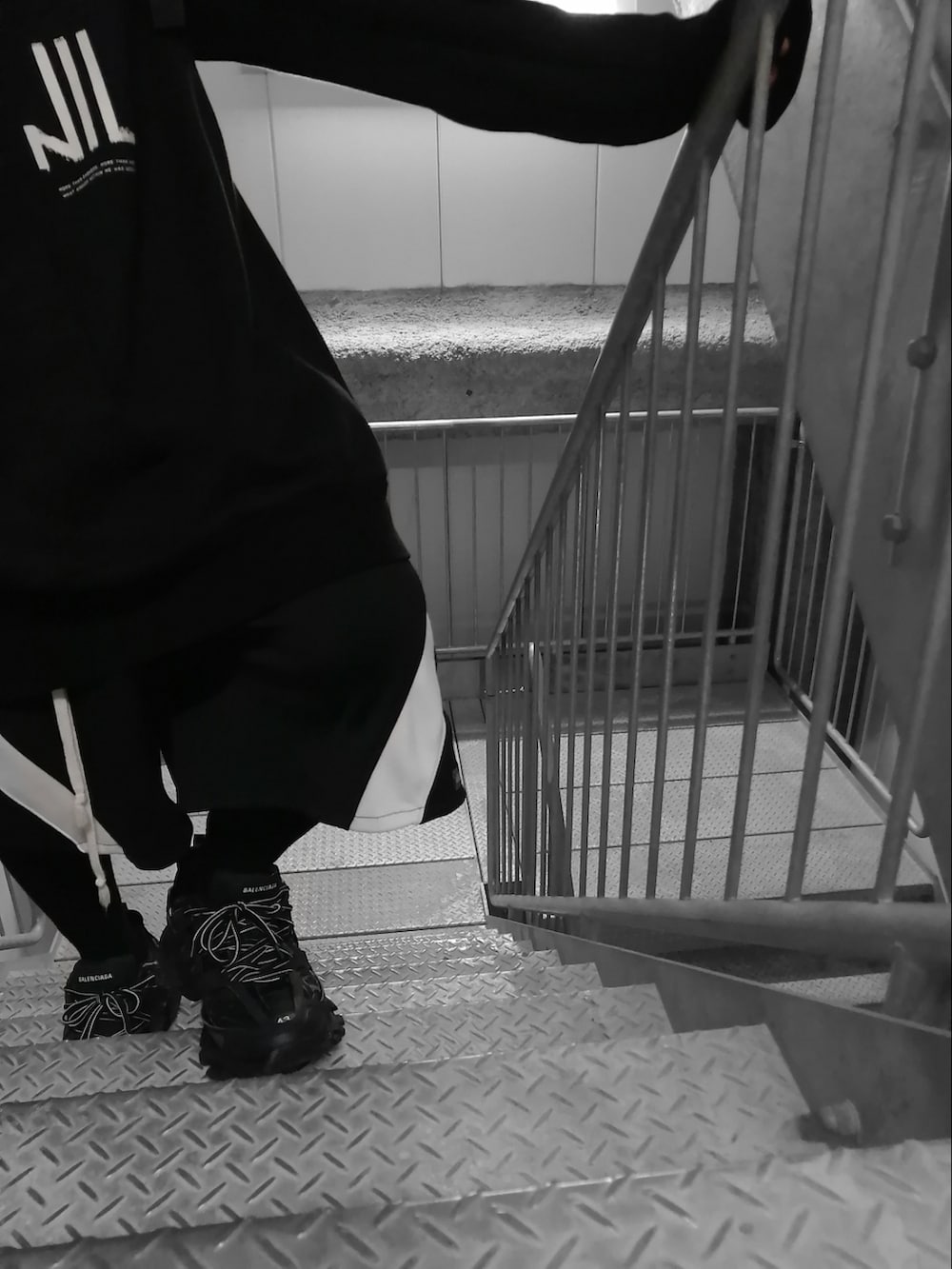 ブラック系のパーカー、ブラック系のパンツ、ブラック系のスニーカーを着用したメンズの春コーディネートの4枚目の写真