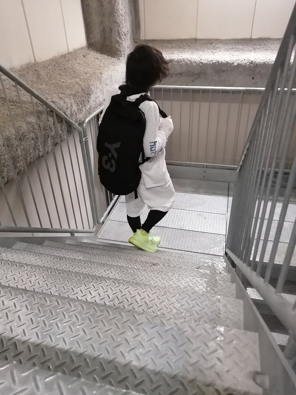 グリーン系のスニーカー、ホワイト系のパンツ、ホワイト系のトップスを着用したメンズの春コーディネートの2枚目の写真