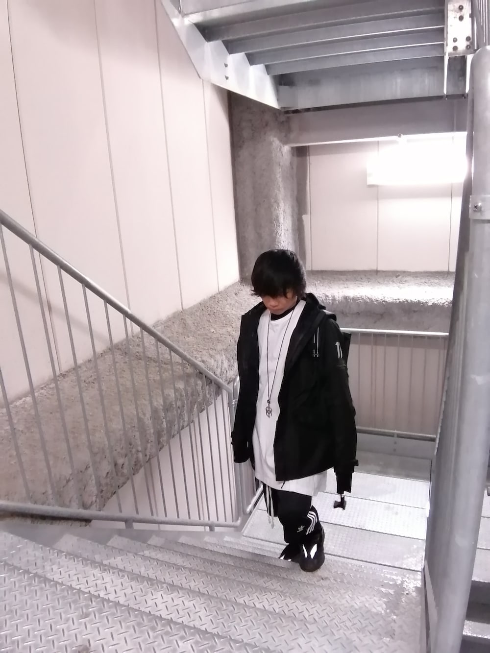 ブラック系のスニーカー、ブラック系のパンツ、ブラック系のバックパック/リュックを着用したメンズの春コーディネートの5枚目の写真