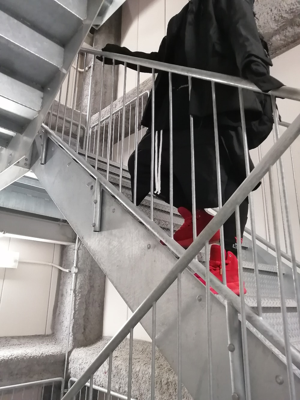 レッド系のスニーカー、ブラック系のパンツ、ブラック系のジャケット/アウターを着用したメンズの春コーディネートの4枚目の写真