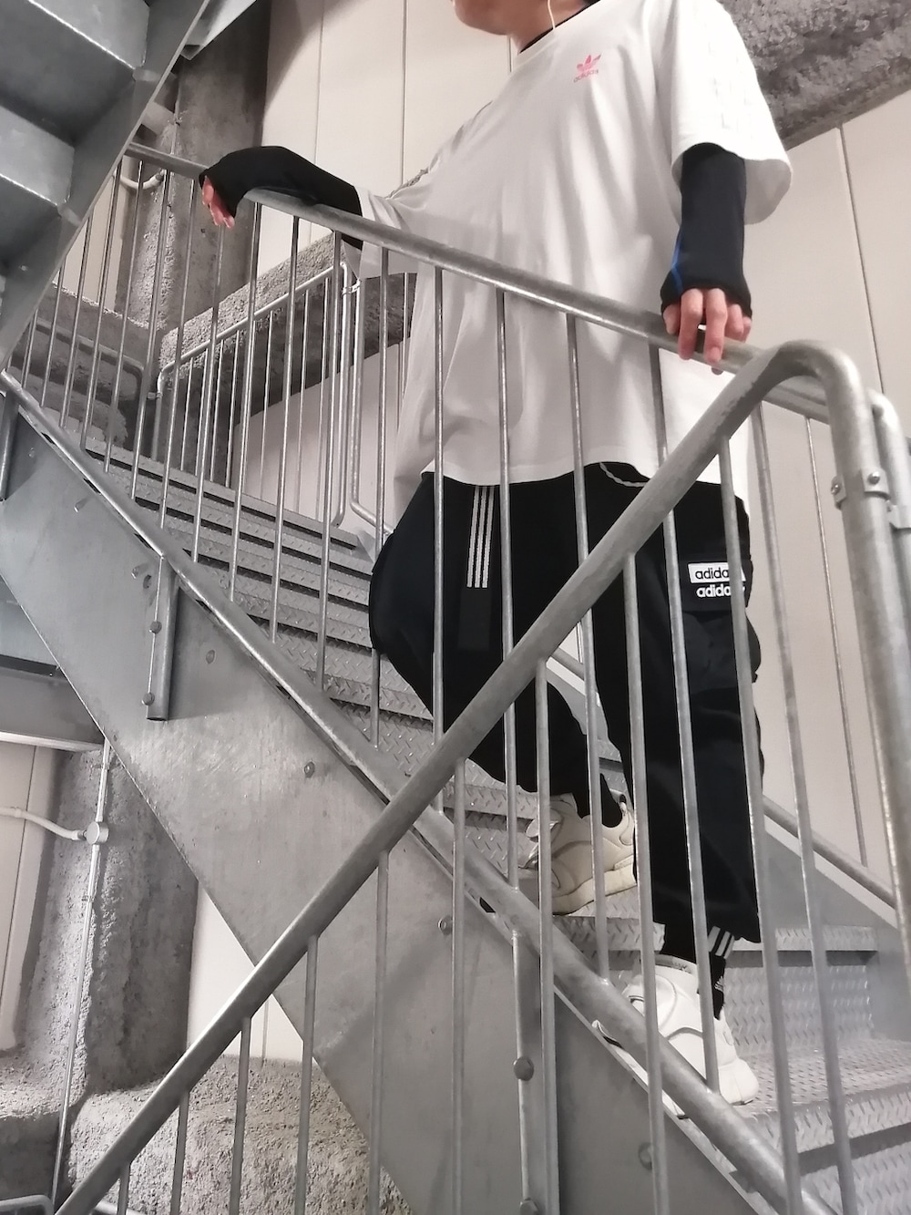 ホワイト系のスニーカー、ブラック系のカーゴパンツ、ホワイト系のトップスを着用したメンズの春コーディネートの3枚目の写真