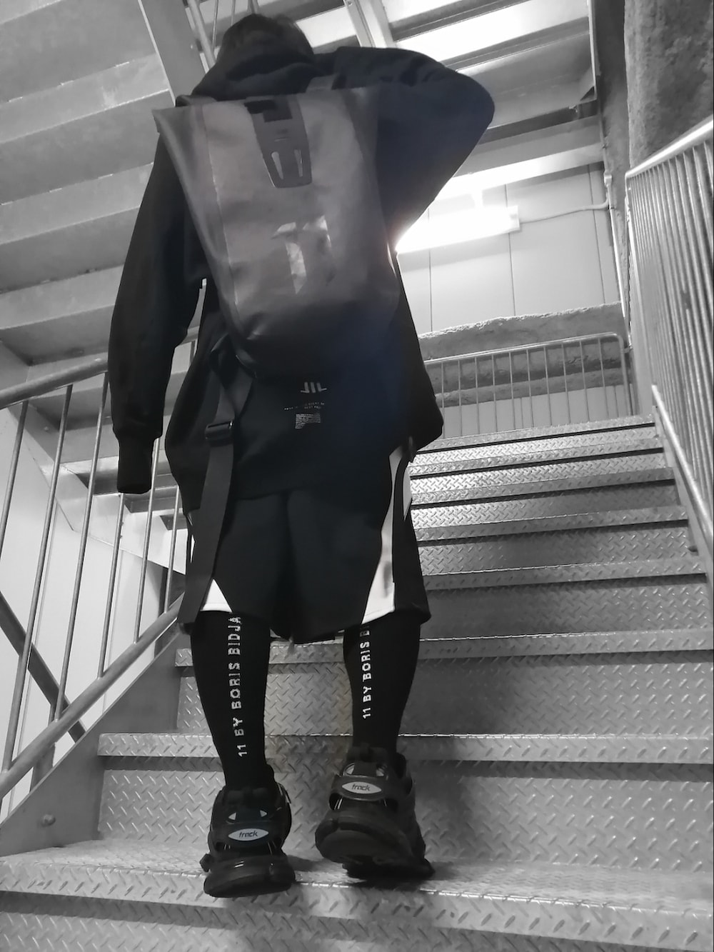 ブラック系のパーカー、ブラック系のパンツ、ブラック系のスニーカーを着用したメンズの春コーディネートの2枚目の写真