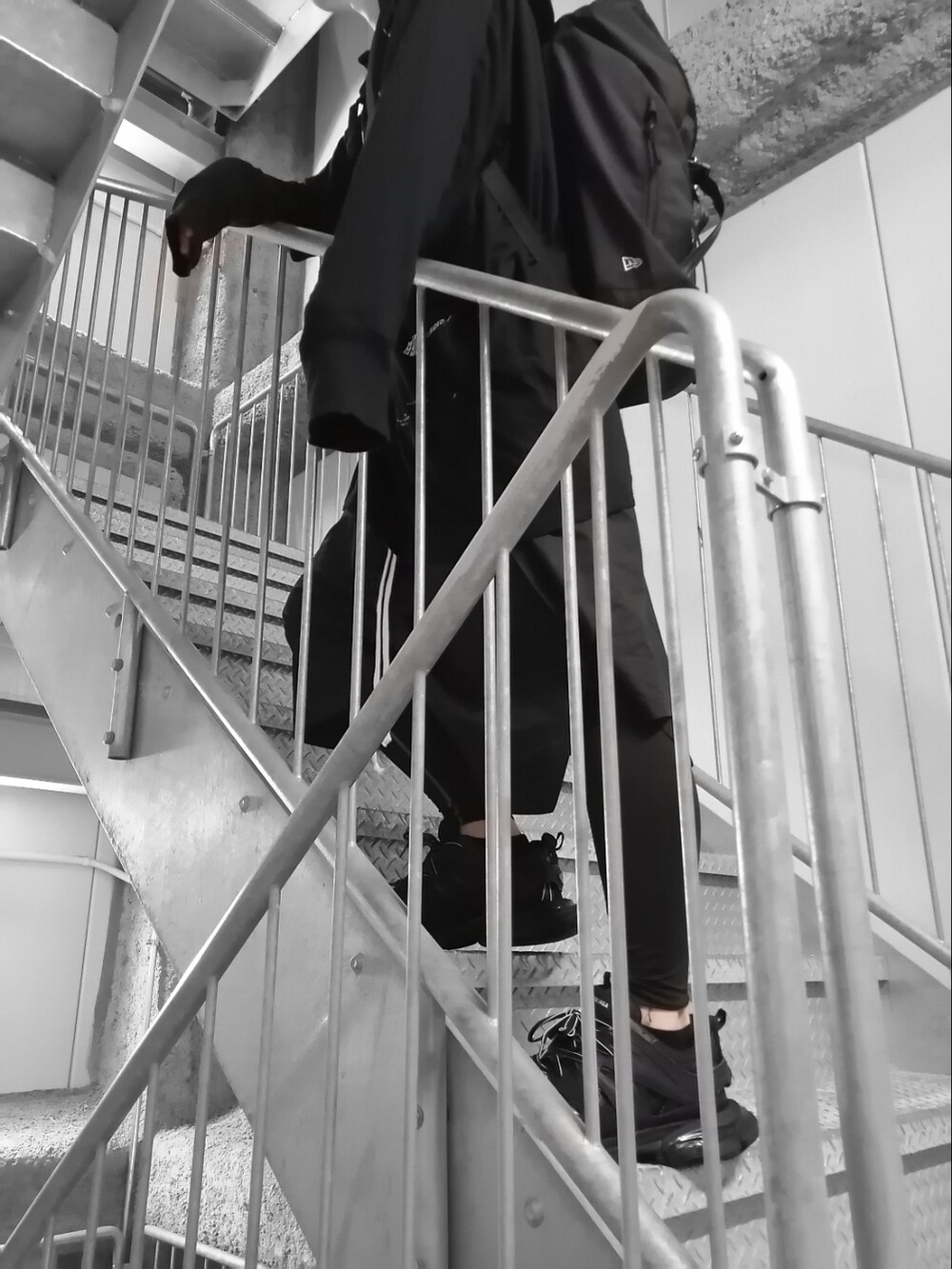 ブラック系のスニーカー、ブラック系のTシャツ/カットソー、ブラック系のパンツを着用したメンズの春コーディネートの3枚目の写真