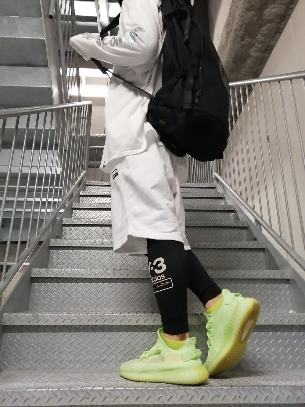 グリーン系のスニーカー、ホワイト系のパンツ、ホワイト系のトップスを着用したメンズの春コーディネートの3枚目の写真