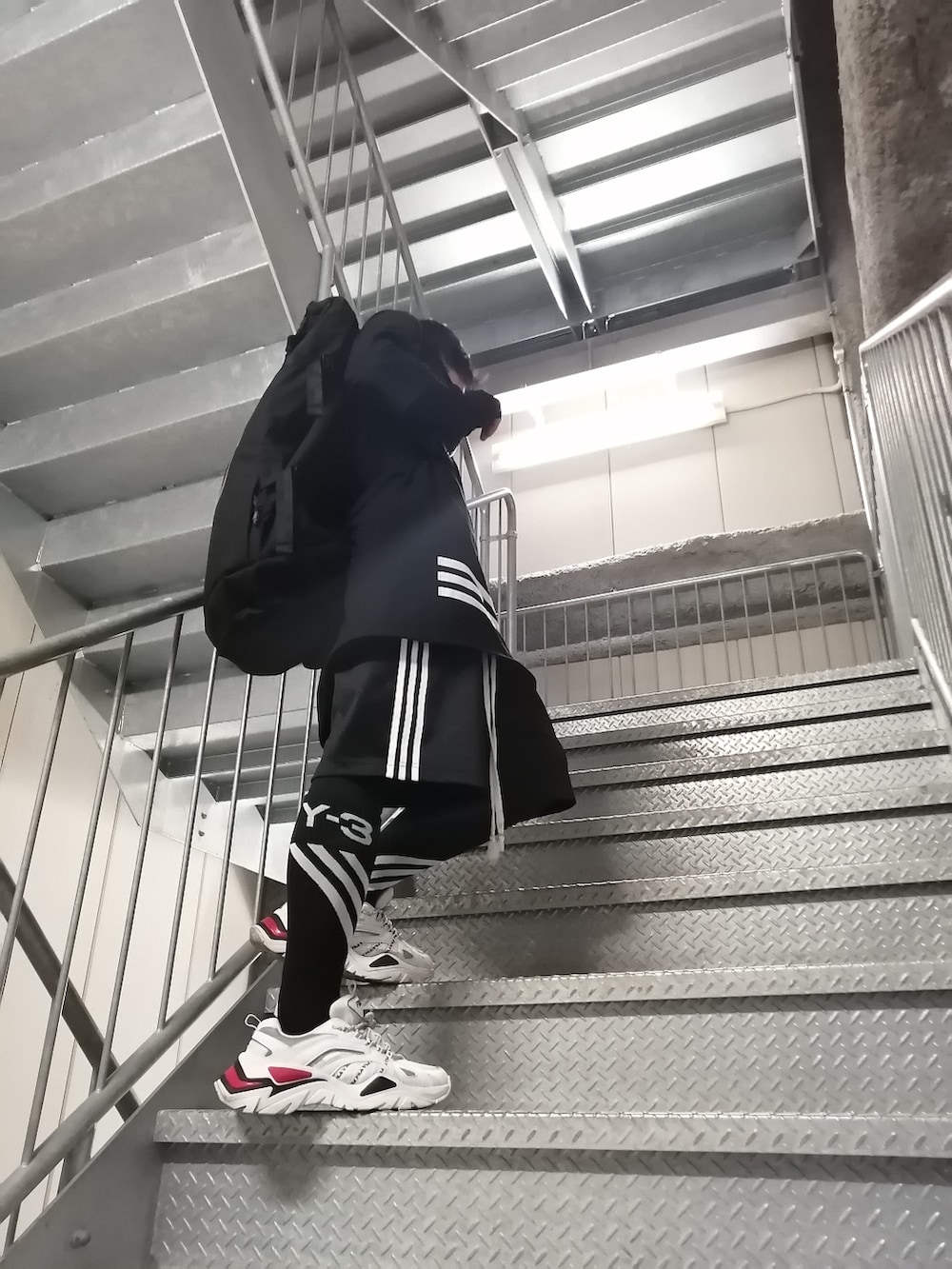 ブラック系のパンツ、ブラック系のTシャツ/カットソー、ブラック系のバックパック/リュックを着用したメンズの春コーディネートの4枚目の写真