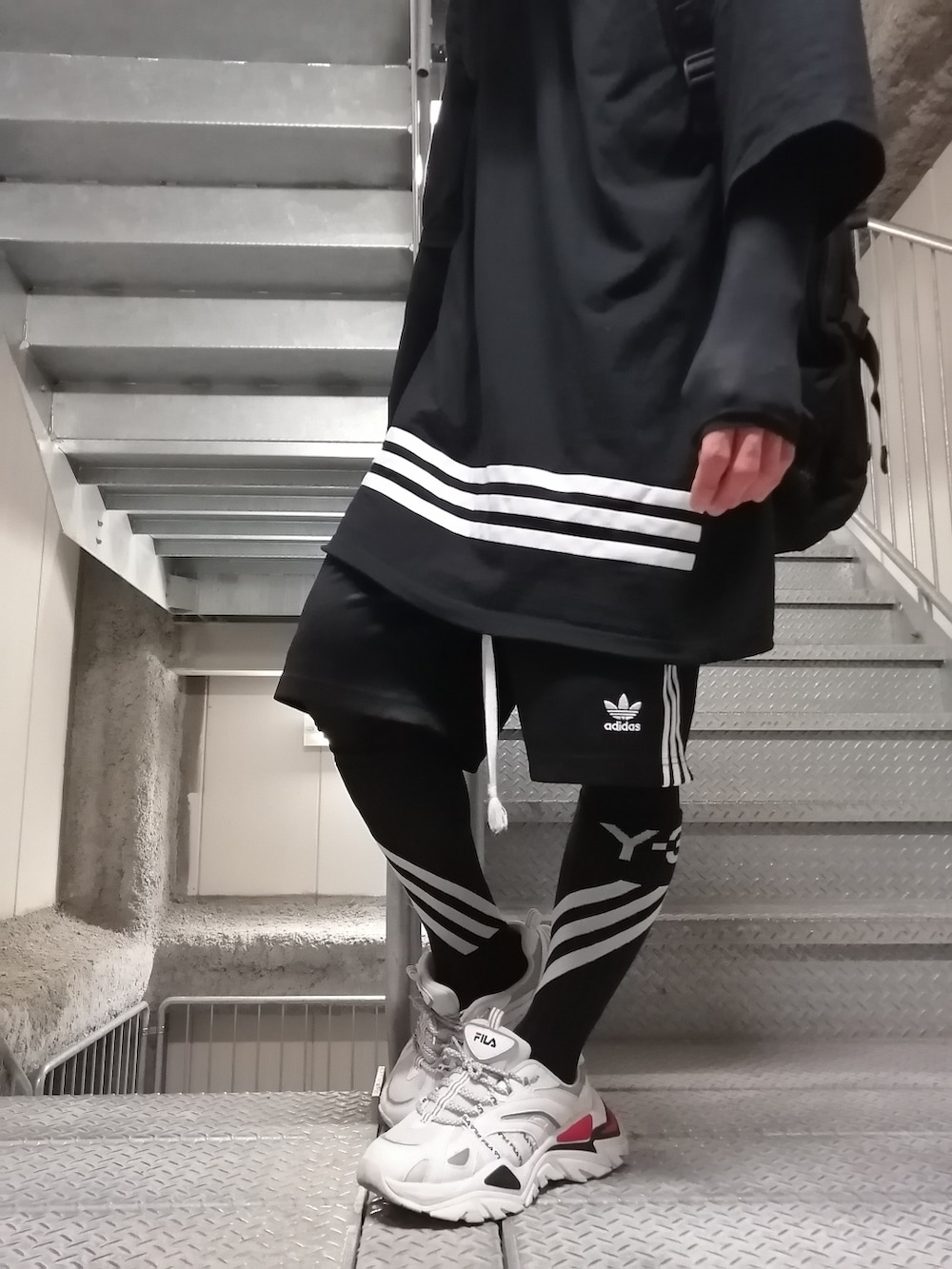 ブラック系のパンツ、ブラック系のTシャツ/カットソー、ブラック系のバックパック/リュックを着用したメンズの春コーディネートの3枚目の写真