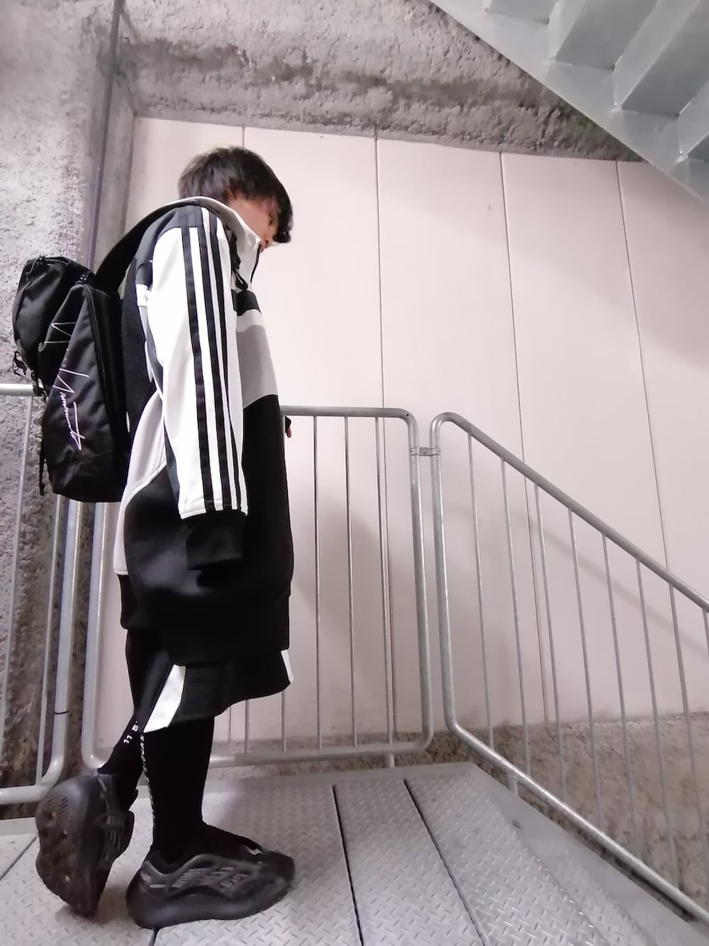 ブラック系のその他パンツ、ブラック系のスニーカー、ブラック系のバッグを着用したメンズの春コーディネートの5枚目の写真