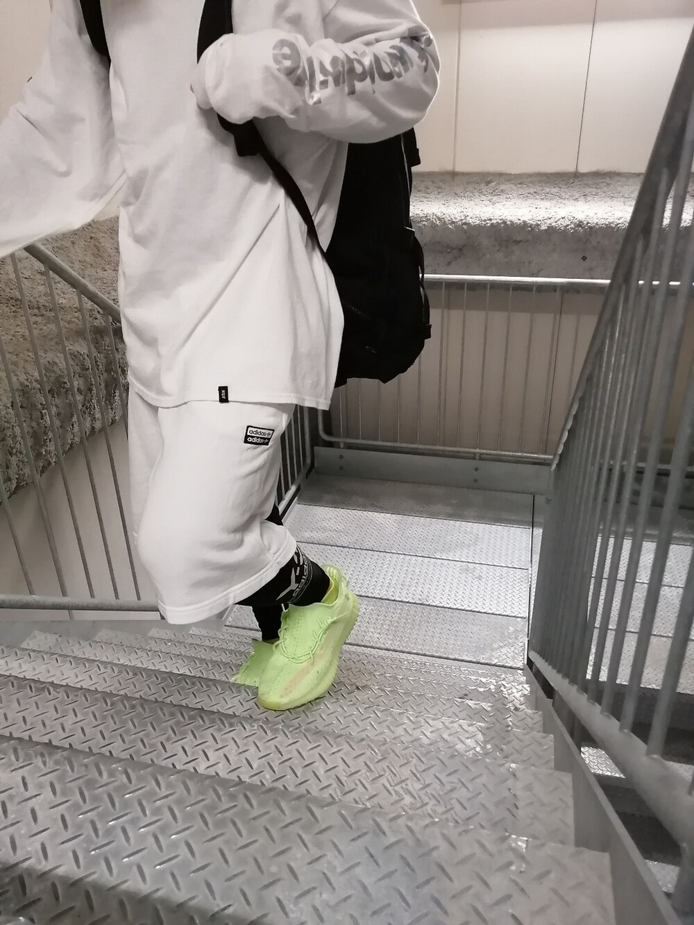 グリーン系のスニーカー、ホワイト系のパンツ、ホワイト系のトップスを着用したメンズの春コーディネートの5枚目の写真