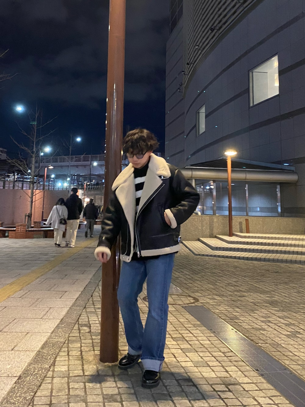 ブラック系のその他シューズ、ブルー系のデニムパンツ、ブラック系のムートンコートを着用したメンズの冬コーディネートの2枚目の写真