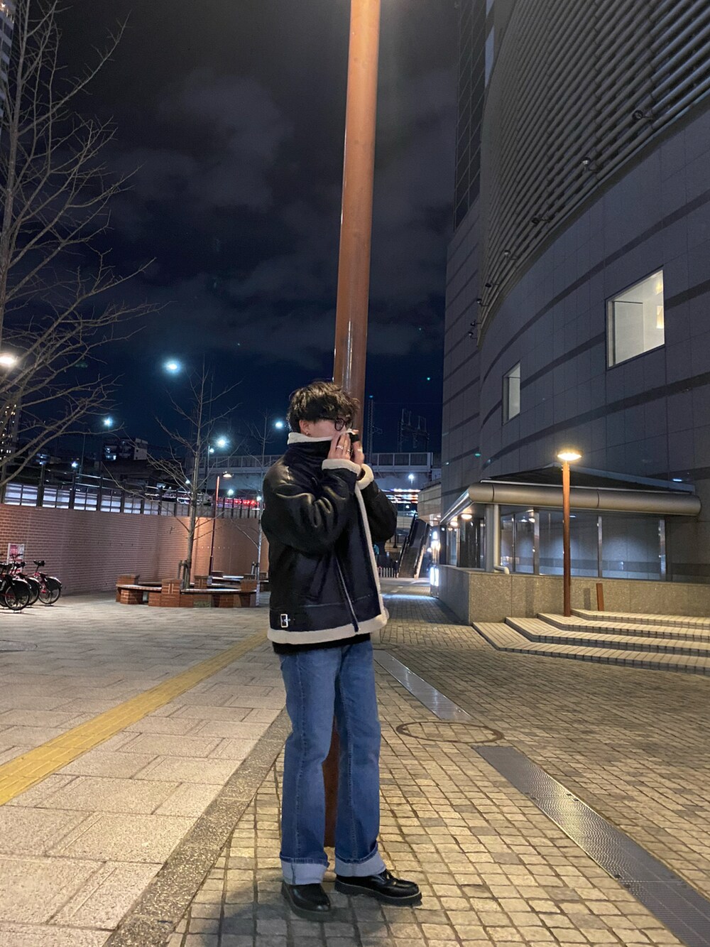 ブラック系のその他シューズ、ブルー系のデニムパンツ、ブラック系のムートンコートを着用したメンズの冬コーディネートの3枚目の写真