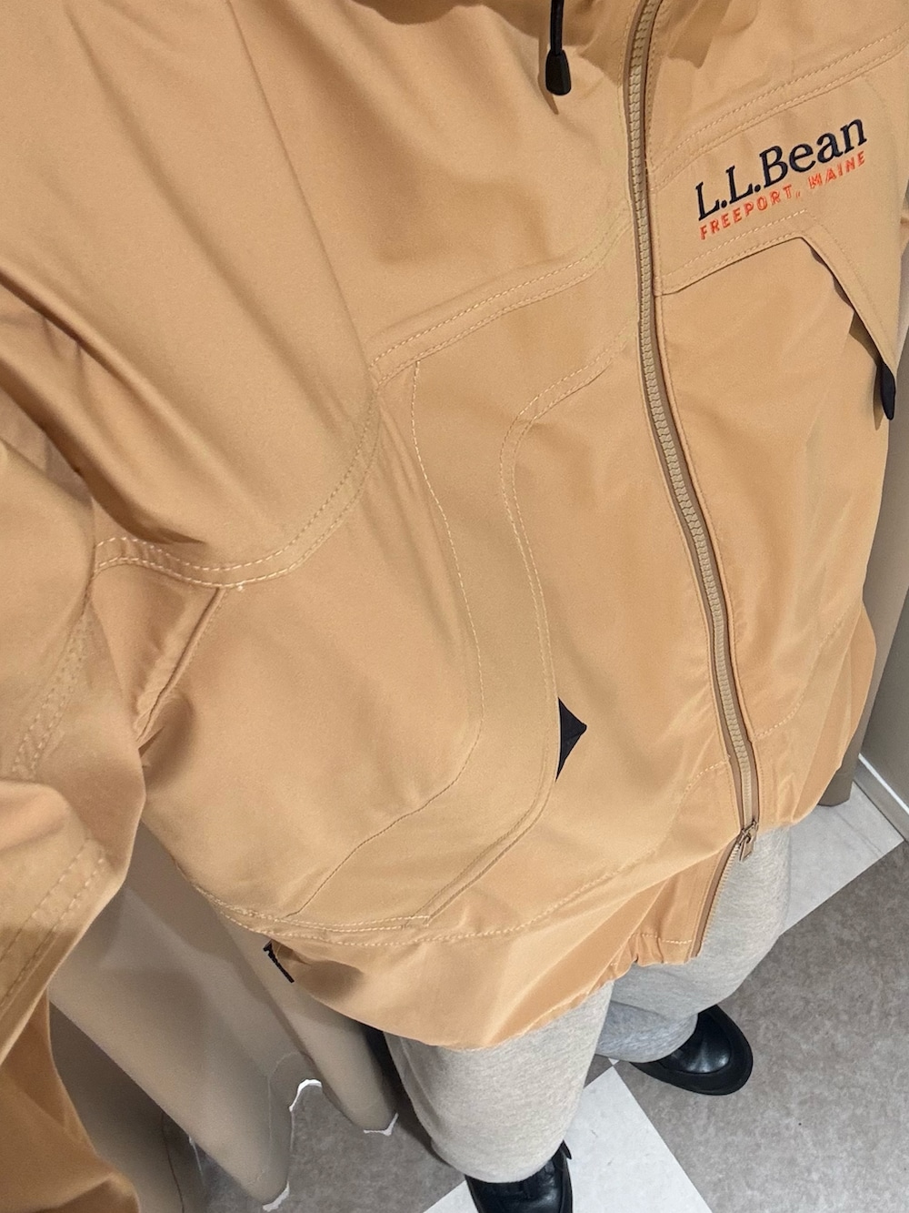 イエロー系のマウンテンパーカー、グレー系のスウェットパンツを着用したメンズの秋コーディネートの2枚目の写真