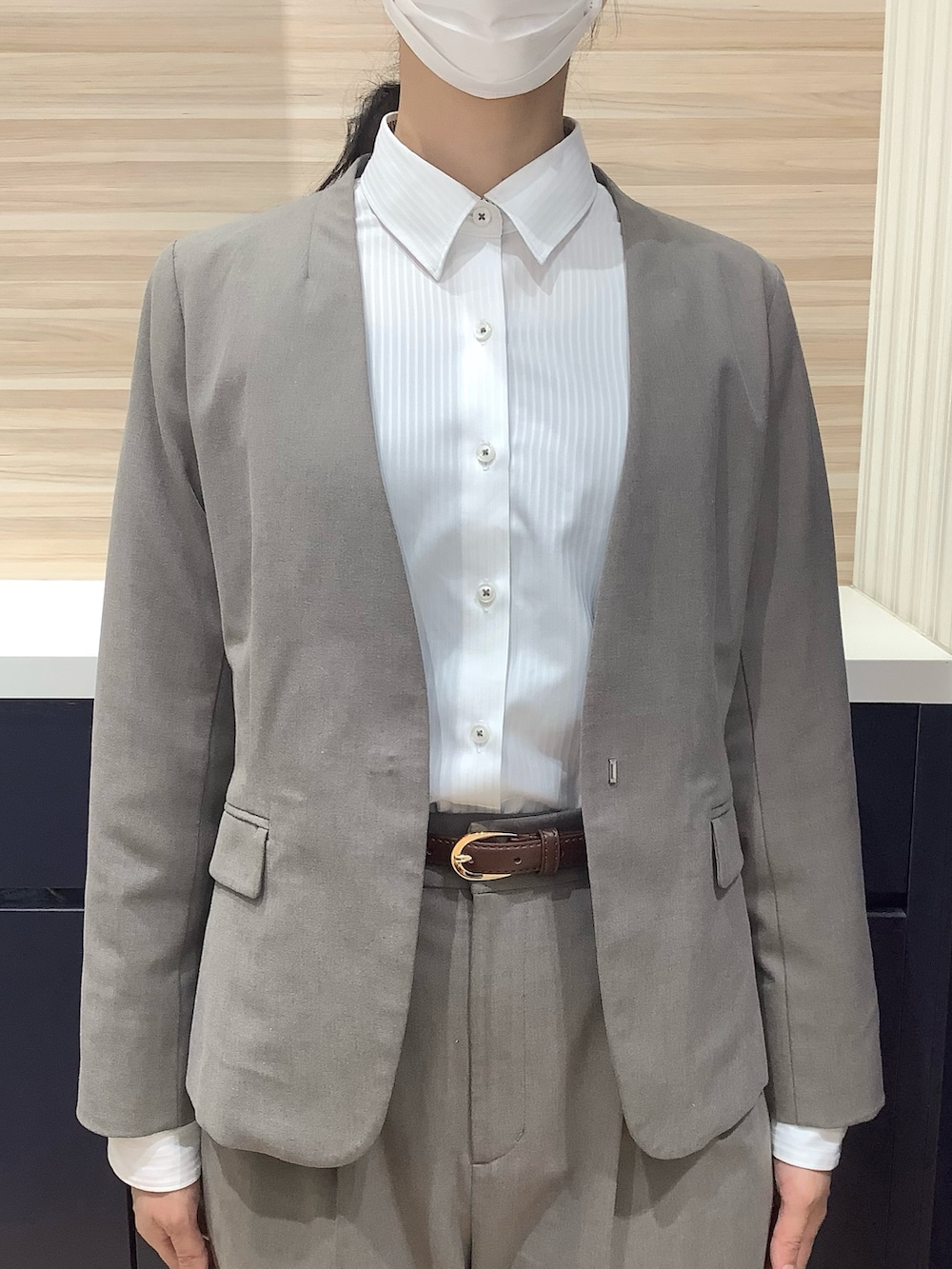 ホワイト系のビジネスシャツを着用したレディースの春コーディネートの2枚目の写真