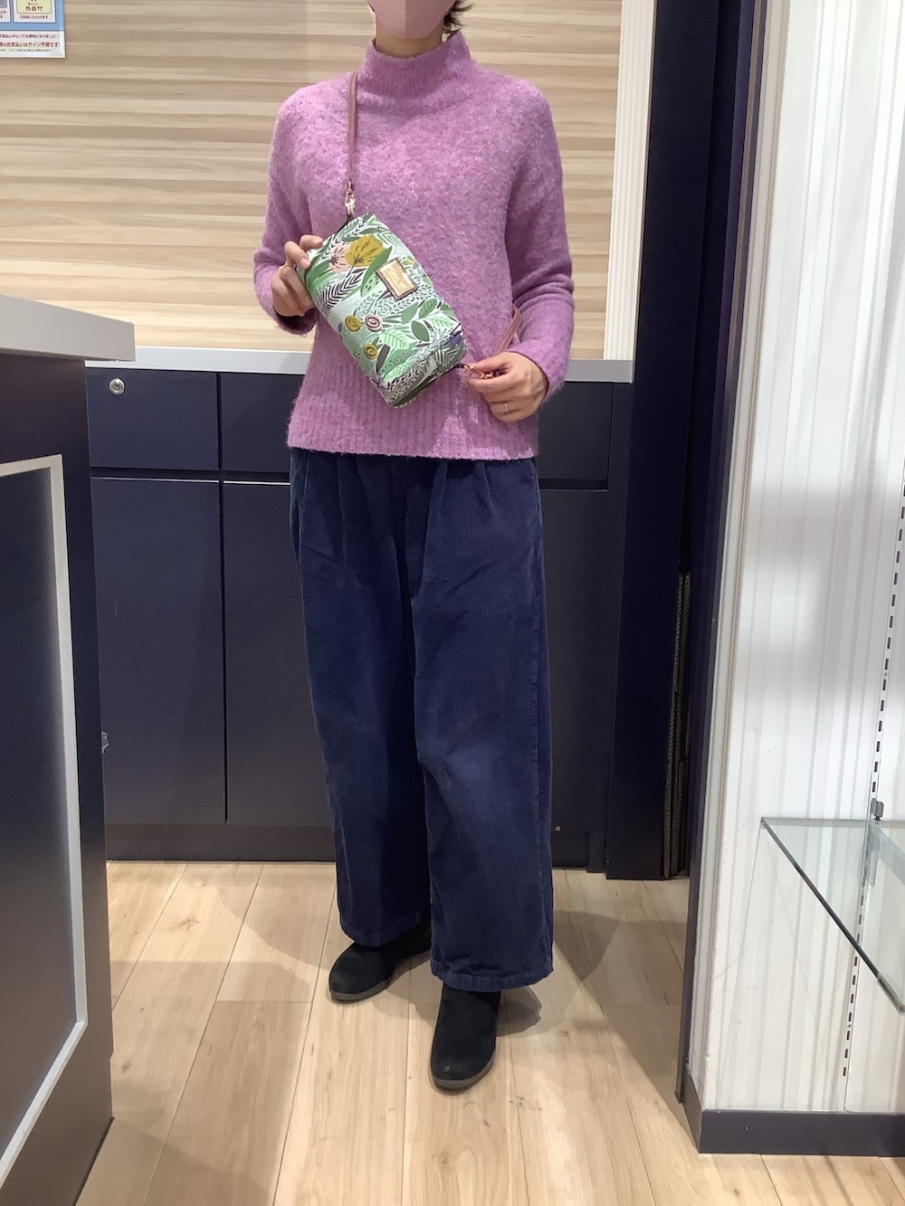 ピンク系のニット/セーター、グリーン系のポーチを着用したレディースの冬コーディネートの2枚目の写真