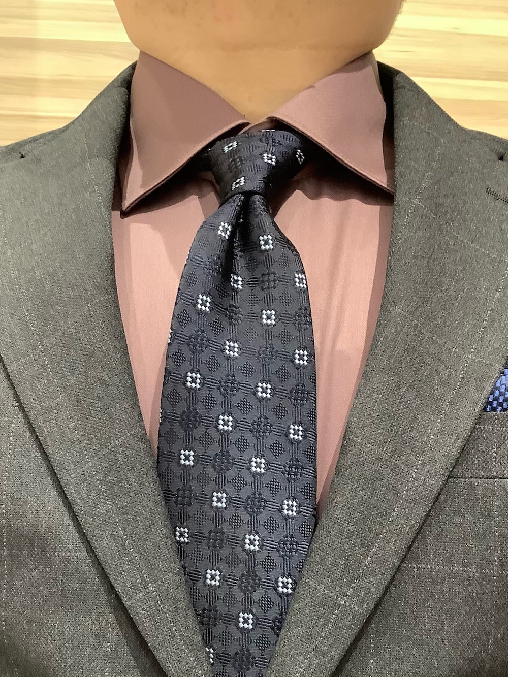 ブルー系のネクタイ、レッド系のビジネスシャツを着用したメンズの冬コーディネートの3枚目の写真