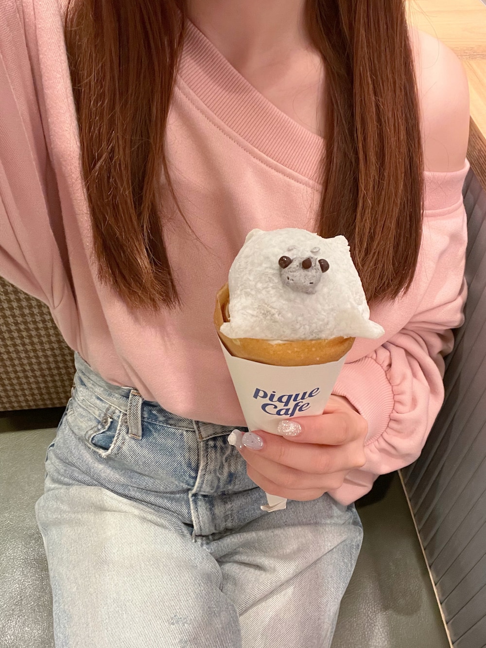 ピンク系のスウェット、ベージュ系のバッグ、ブルー系のデニムパンツを着用したレディースの夏コーディネートの3枚目の写真