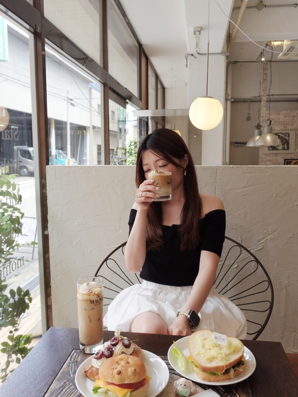 ホワイト系のスニーカー、ブラック系のトップス、ホワイト系のスカートを着用したレディースの夏コーディネートの5枚目の写真