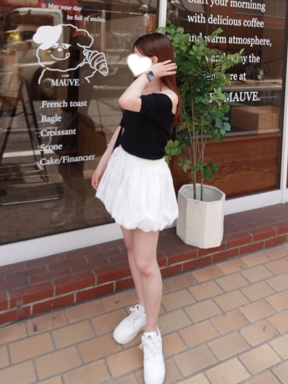 ホワイト系のスニーカー、ブラック系のトップス、ホワイト系のスカートを着用したレディースの夏コーディネートの2枚目の写真