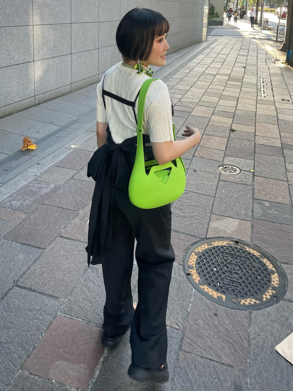 ブラック系のサンダル、ブラック系のスラックス、ブラック系のベストを着用したレディースの秋コーディネートの4枚目の写真