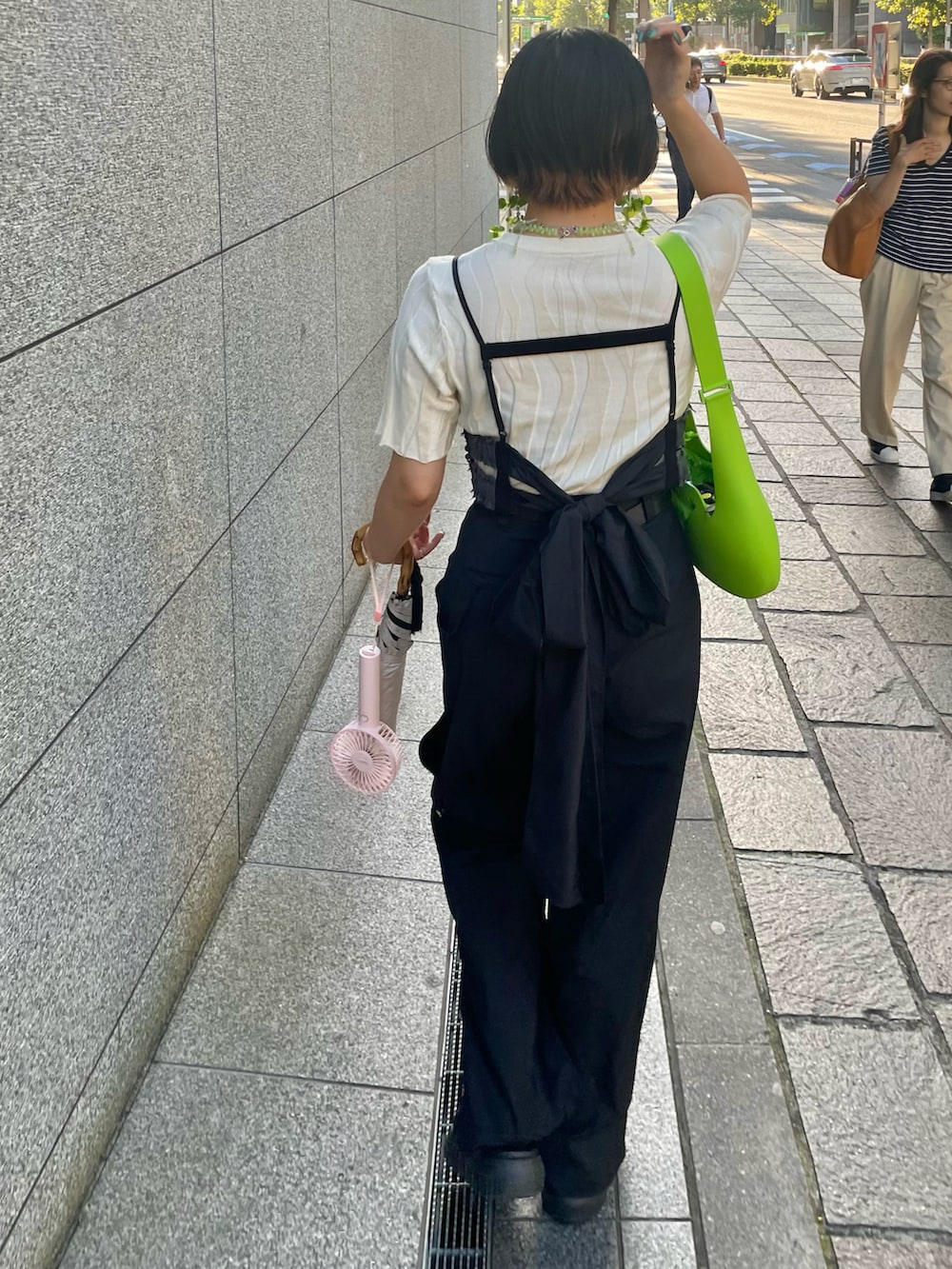 ブラック系のサンダル、ブラック系のスラックス、ブラック系のベストを着用したレディースの秋コーディネートの5枚目の写真