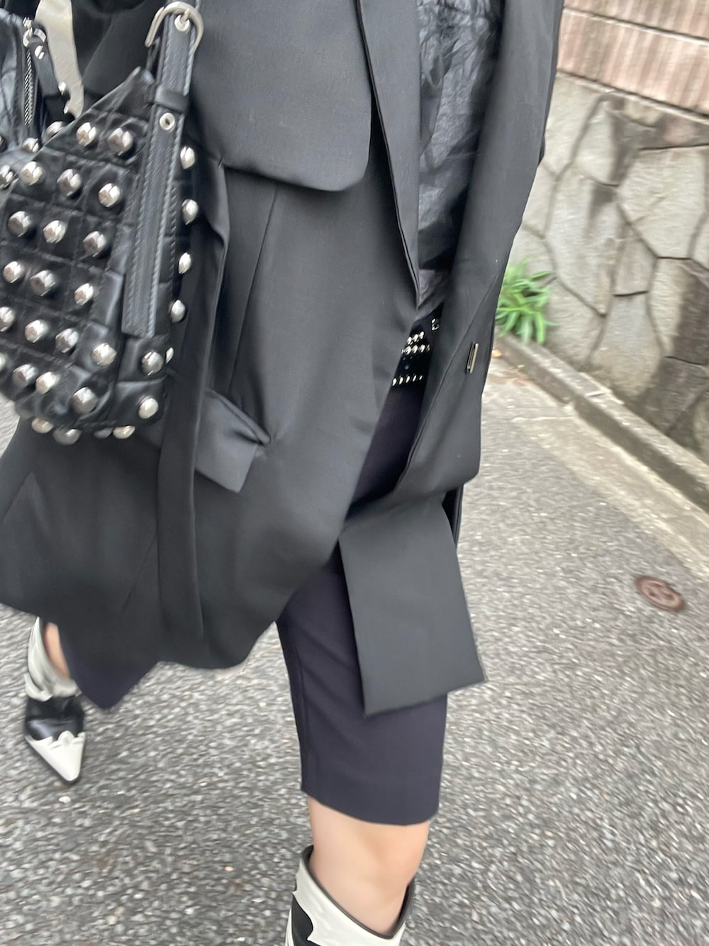 ブラック系のテーラードジャケット、ブラック系のハンドバッグ、グレー系のTシャツ/カットソーを着用したレディースの秋コーディネートの3枚目の写真