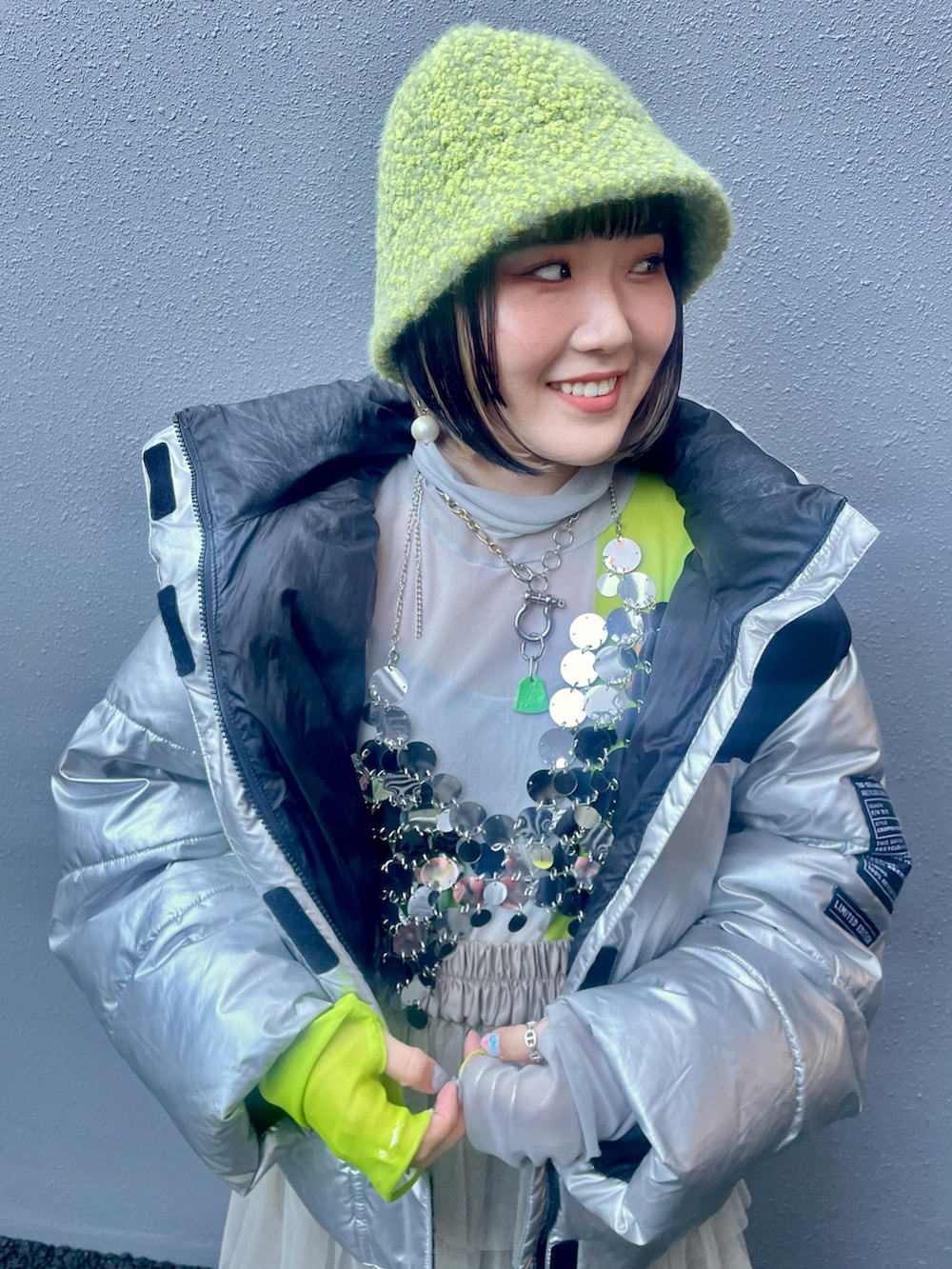 ベージュ系のスカート、シルバー系のダウンジャケット/コート、シルバー系のその他トップスを着用したレディースの春コーディネートの5枚目の写真