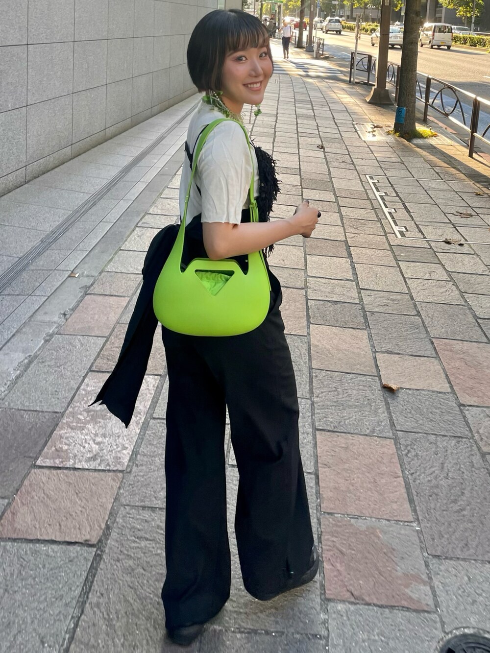 ブラック系のサンダル、ブラック系のスラックス、ブラック系のベストを着用したレディースの秋コーディネートの3枚目の写真