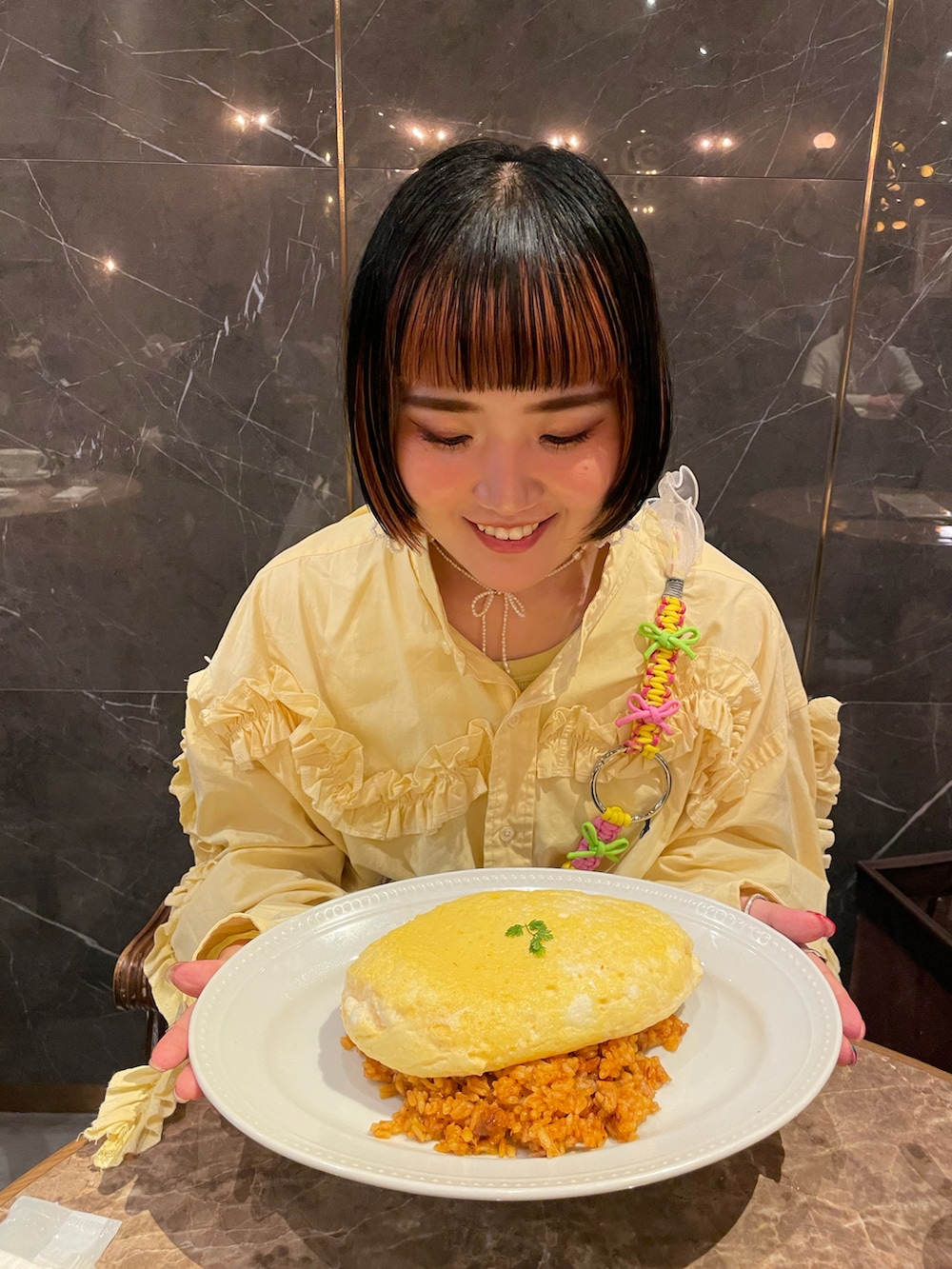 シルバー系のダウンジャケット/コート、ブラック系のハンドバッグ、イエロー系のシャツ/ブラウスを着用したレディースの冬コーディネートの4枚目の写真