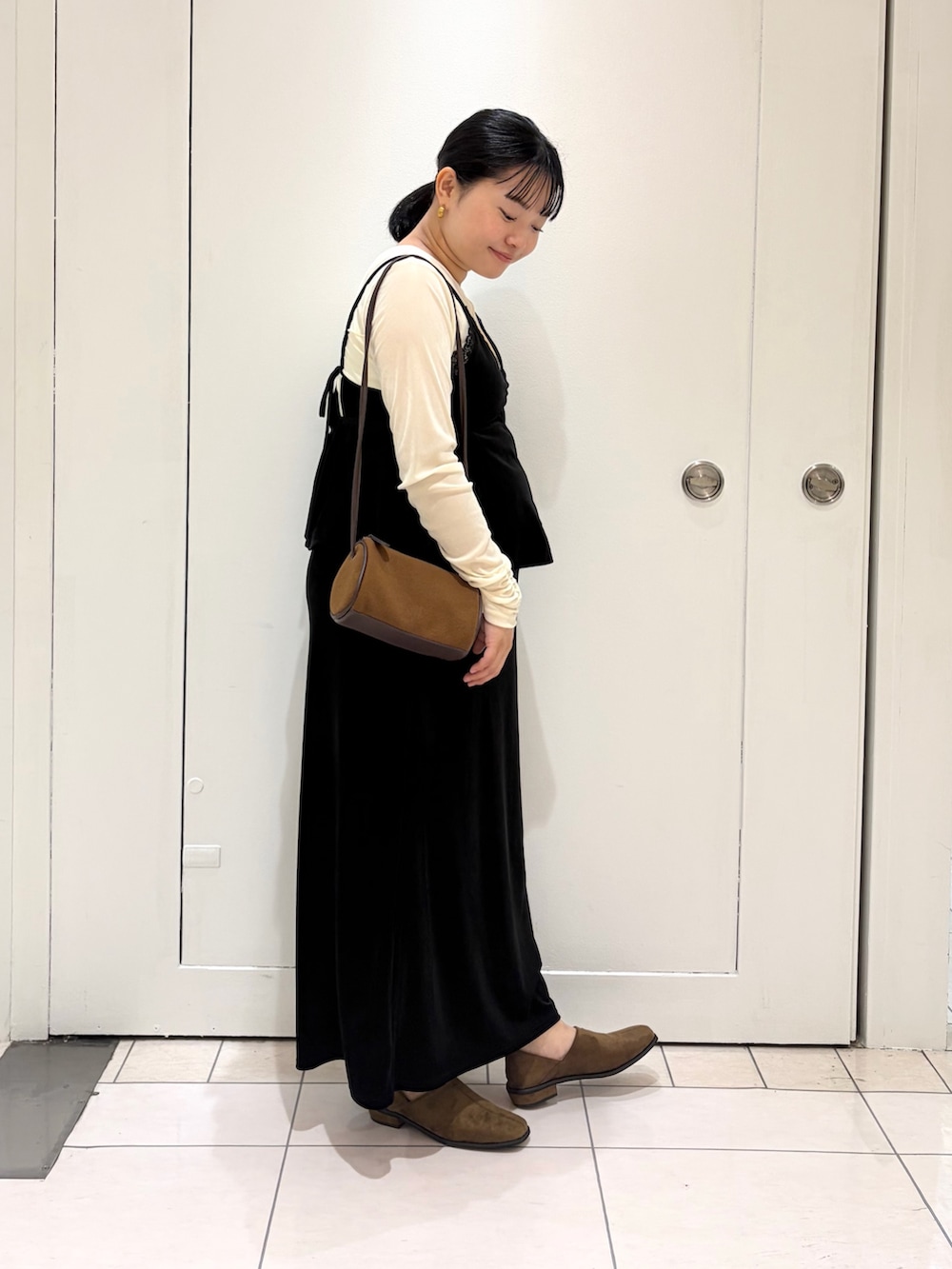 ホワイト系のTシャツ/カットソー、ブラック系のセットアップ、ブラウン系のショルダーバッグを着用したレディースの秋コーディネートの4枚目の写真