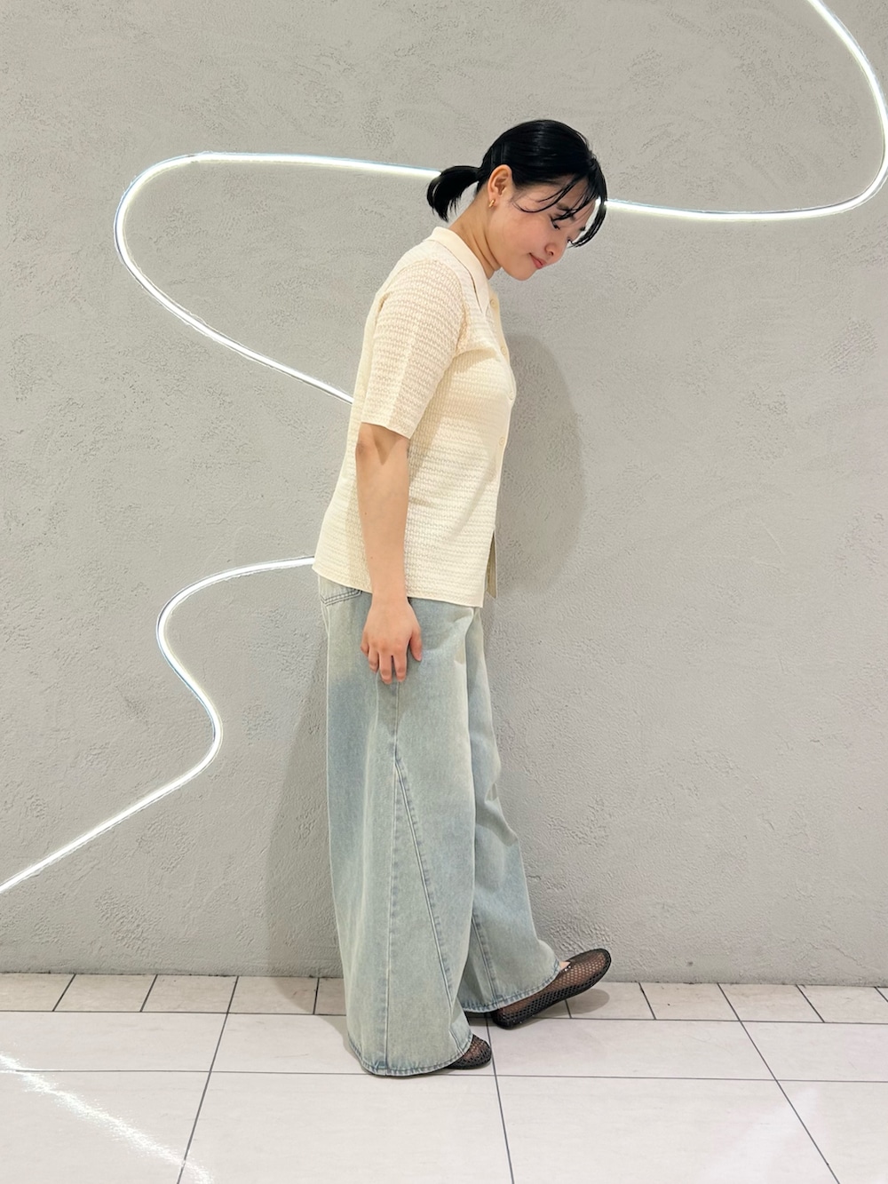 ホワイト系のニット/セーター、ブルー系のデニムパンツ、ブラック系のバレエシューズを着用したレディースの春コーディネートの2枚目の写真