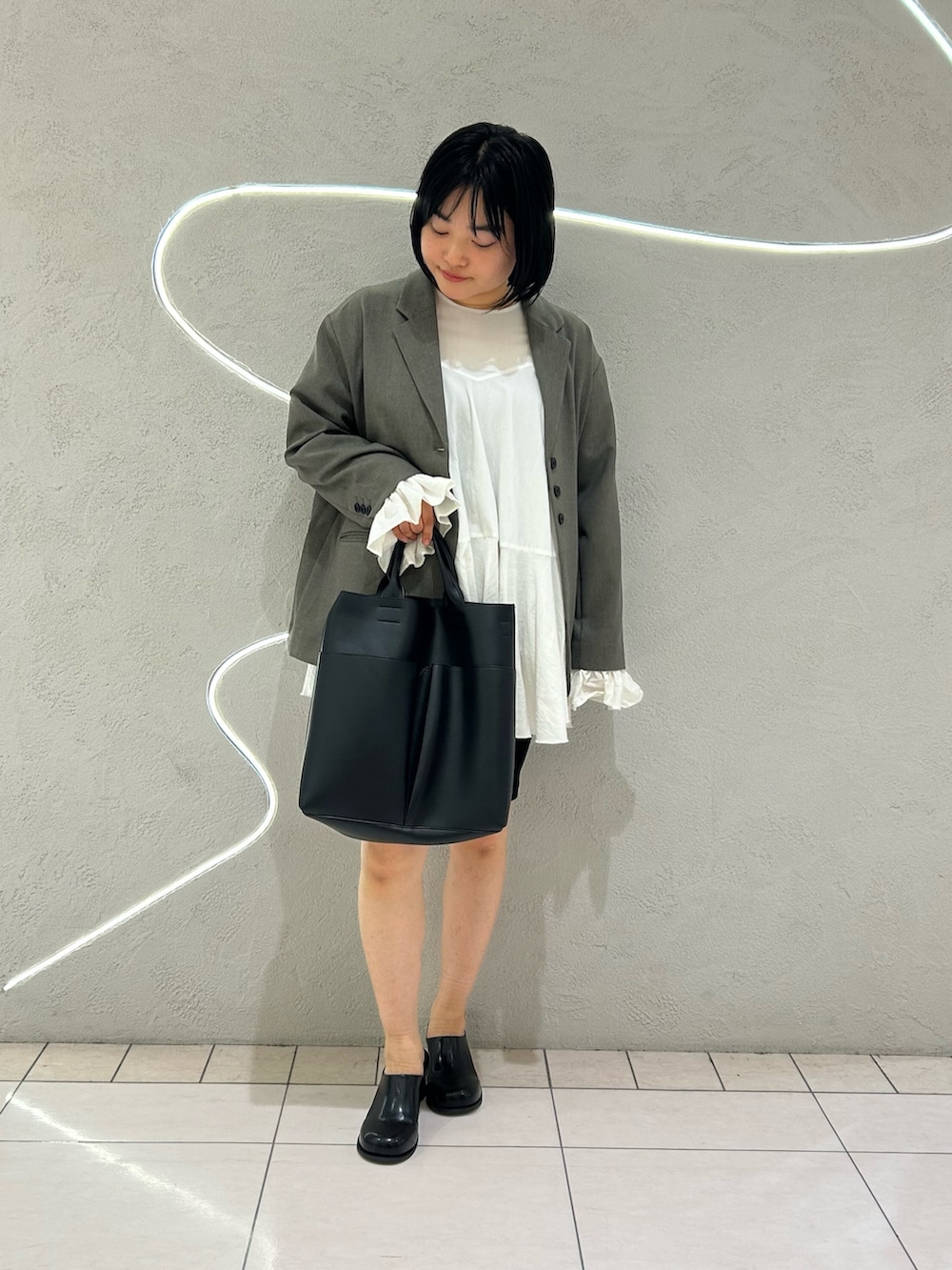 グレー系のその他アウター、ホワイト系のワンピース、ブラック系のその他パンツを着用したレディースの冬コーディネートの2枚目の写真