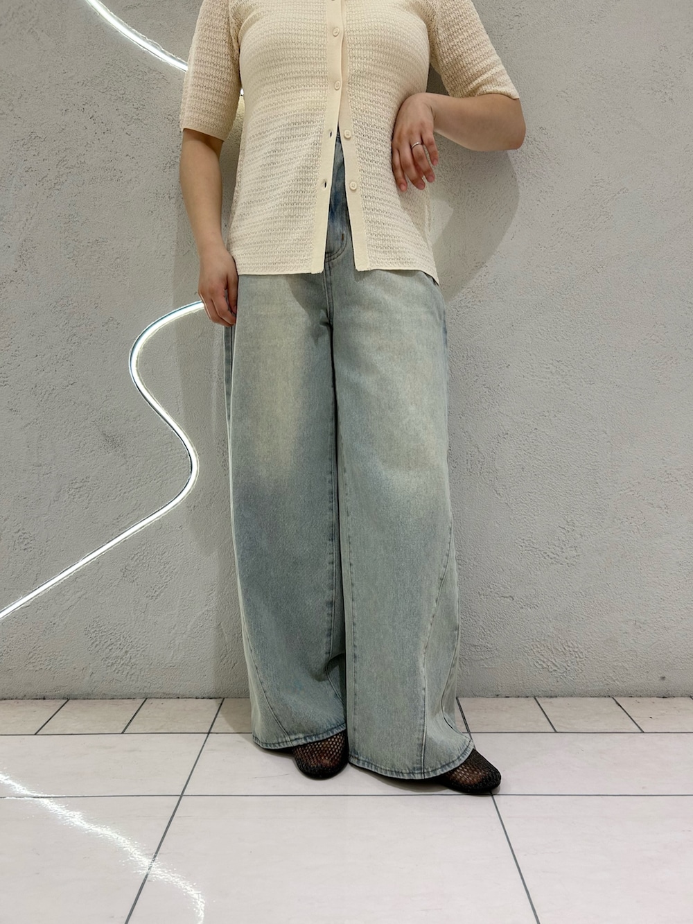 ホワイト系のニット/セーター、ブルー系のデニムパンツ、ブラック系のバレエシューズを着用したレディースの春コーディネートの4枚目の写真