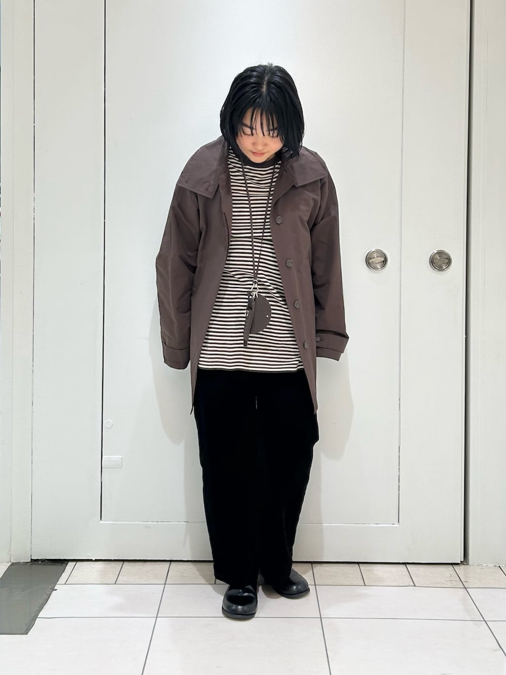 ブラウン系のその他アウター、ブラック系のデニムパンツ、ブラウン系のニット/セーターを着用したレディースの冬コーディネートの2枚目の写真