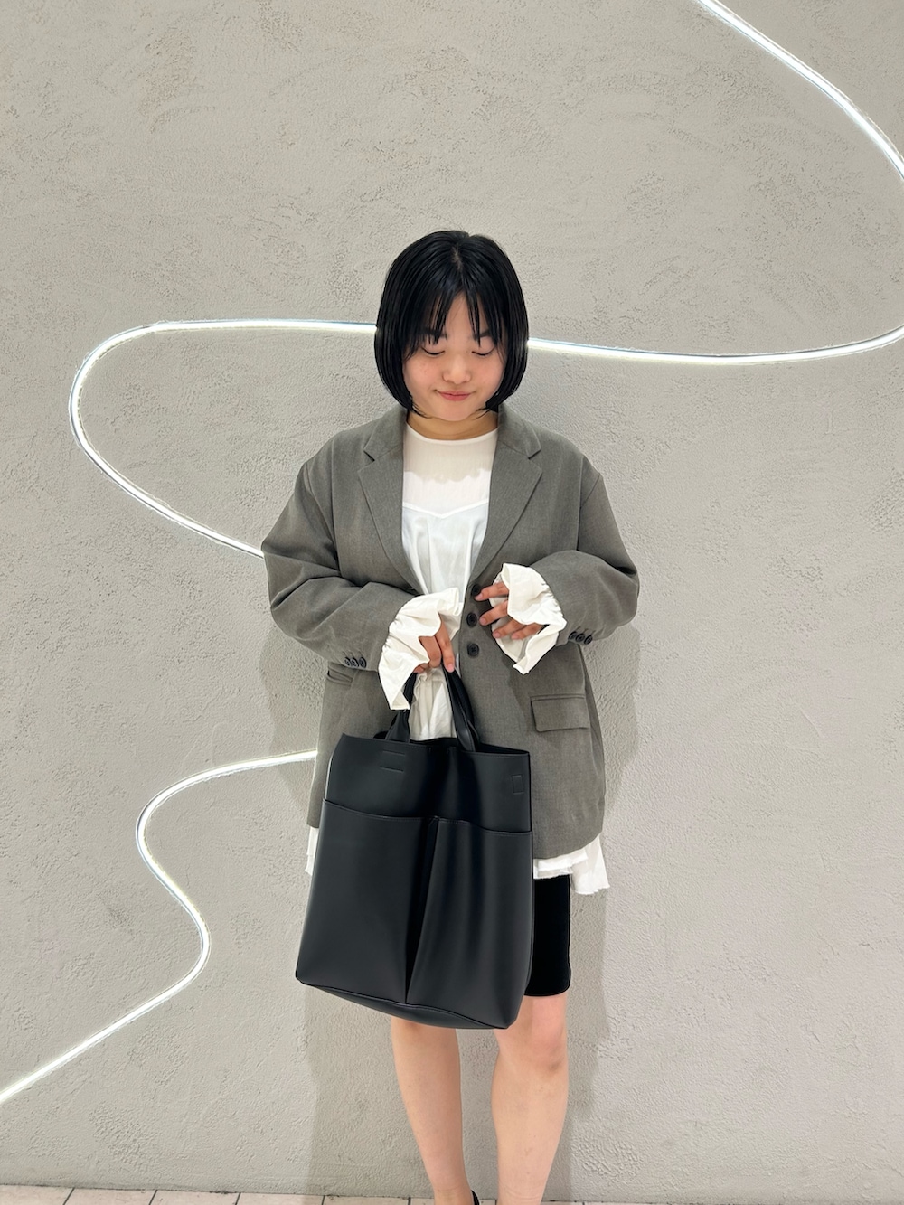 グレー系のその他アウター、ホワイト系のワンピース、ブラック系のその他パンツを着用したレディースの冬コーディネートの5枚目の写真