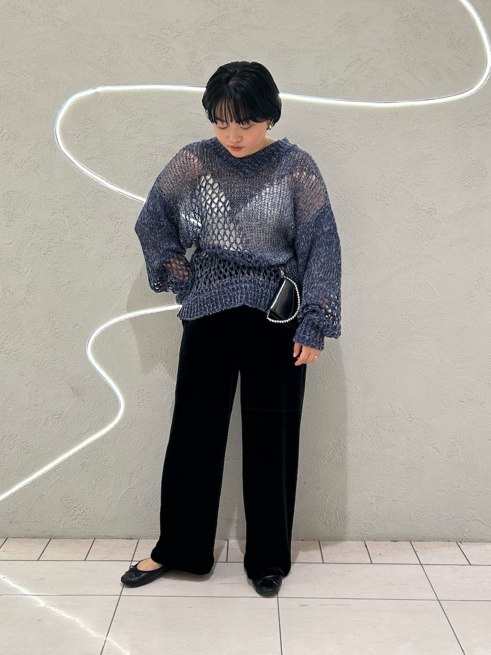 ブルー系のニット/セーター、ブラック系のその他パンツ、ブラック系の財布を着用したレディースの秋コーディネートの2枚目の写真