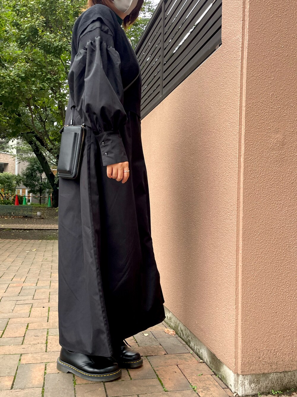 ブラック系のブーツ、ブラック系のワンピース、ブラック系のベストを着用したレディースの秋コーディネートの2枚目の写真