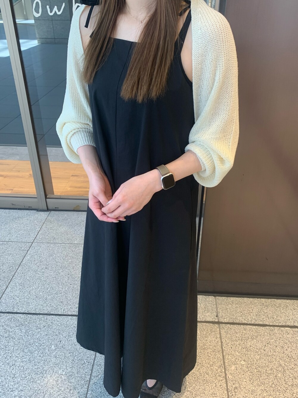 ブラック系のワンピース、ホワイト系のカーディガン/ボレロ、ブラック系のパンプスを着用したレディースの夏コーディネートの3枚目の写真