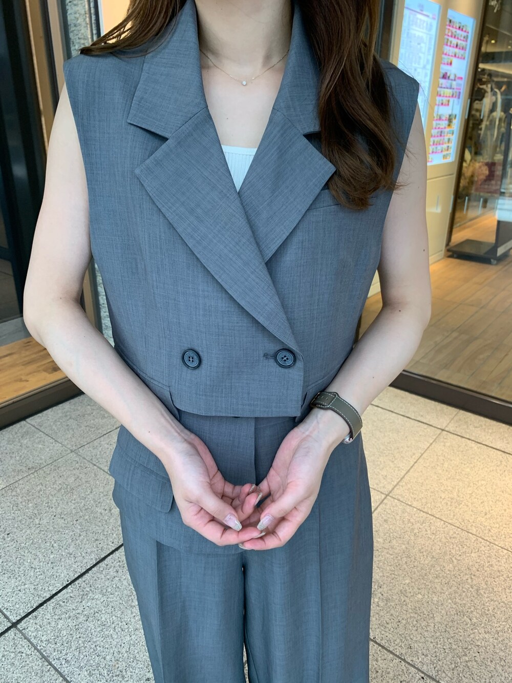 グレー系のスラックス、ブラック系のパンプス、グレー系のテーラードジャケットを着用したレディースの夏コーディネートの3枚目の写真