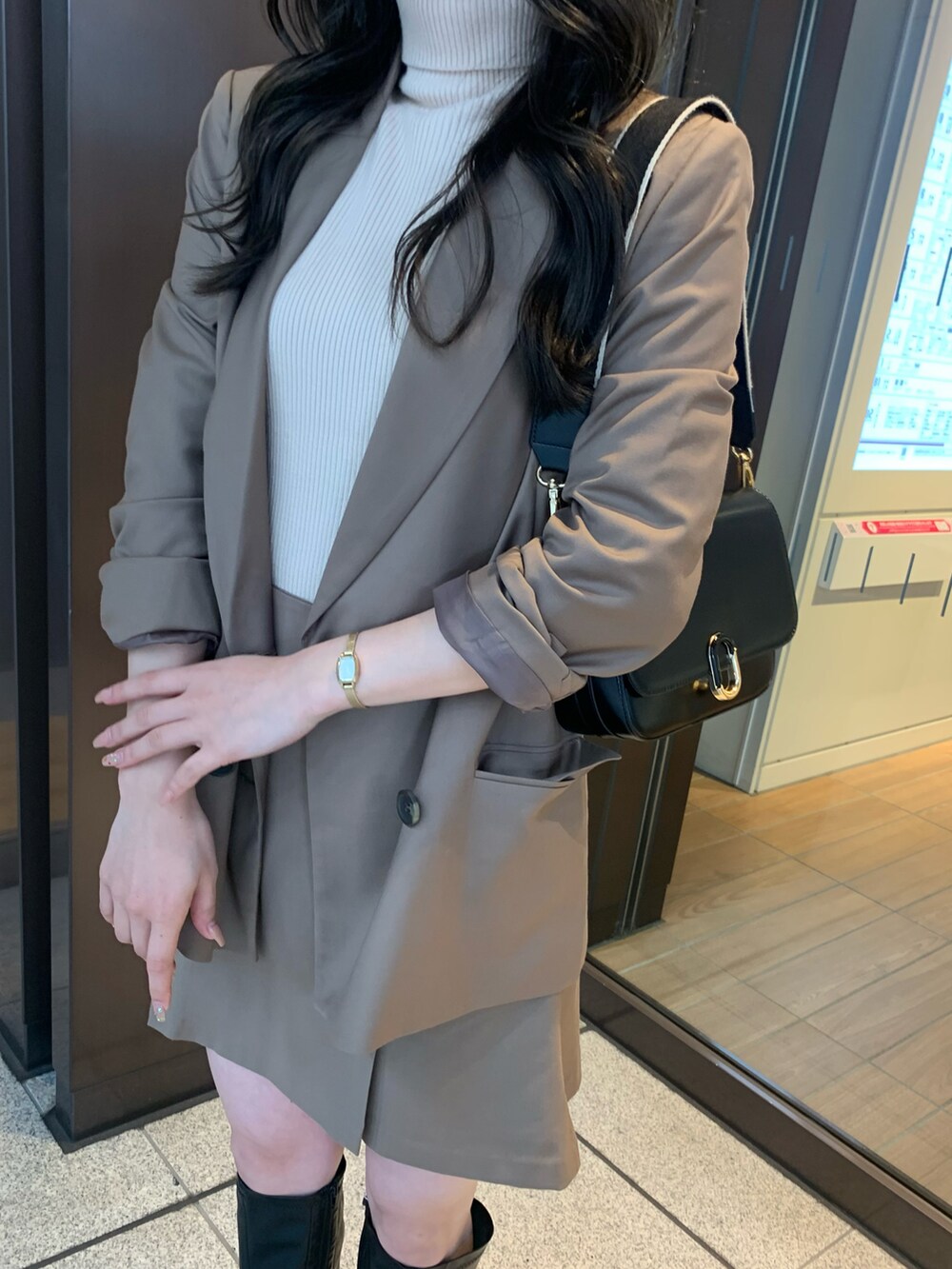 ブラウン系のテーラードジャケット、ブラウン系のスカート、ホワイト系のニット/セーターを着用したレディースの秋コーディネートの2枚目の写真