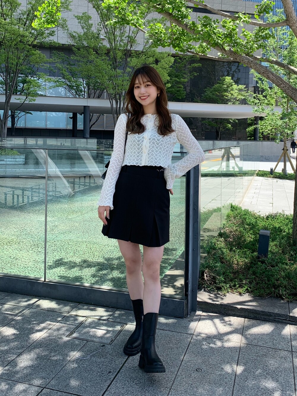 ブラック系のスカート、ブラック系のショルダーバッグを着用したレディースの夏コーディネートの2枚目の写真