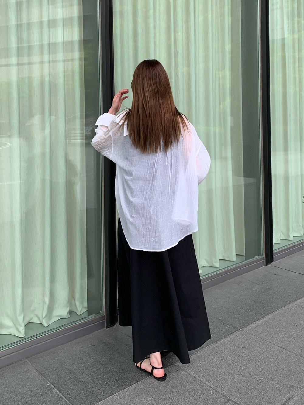 ブラック系のワンピース、ホワイト系のシャツ/ブラウス、ブラック系のサンダルを着用したレディースの夏コーディネートの4枚目の写真