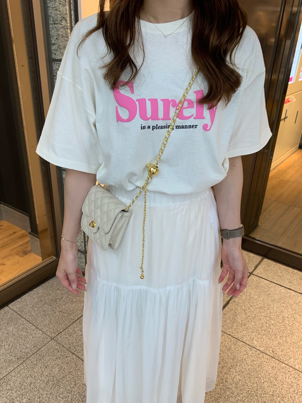 ホワイト系のTシャツ/カットソー、ホワイト系のスカート、ホワイト系のショルダーバッグを着用したレディースの夏コーディネートの3枚目の写真