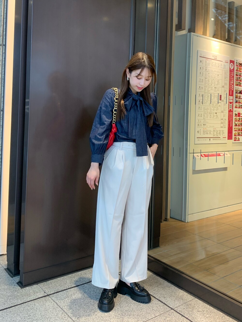 ホワイト系のその他パンツ、ブルー系のシャツ/ブラウス、レッド系のハンドバッグを着用したレディースの秋コーディネートの2枚目の写真