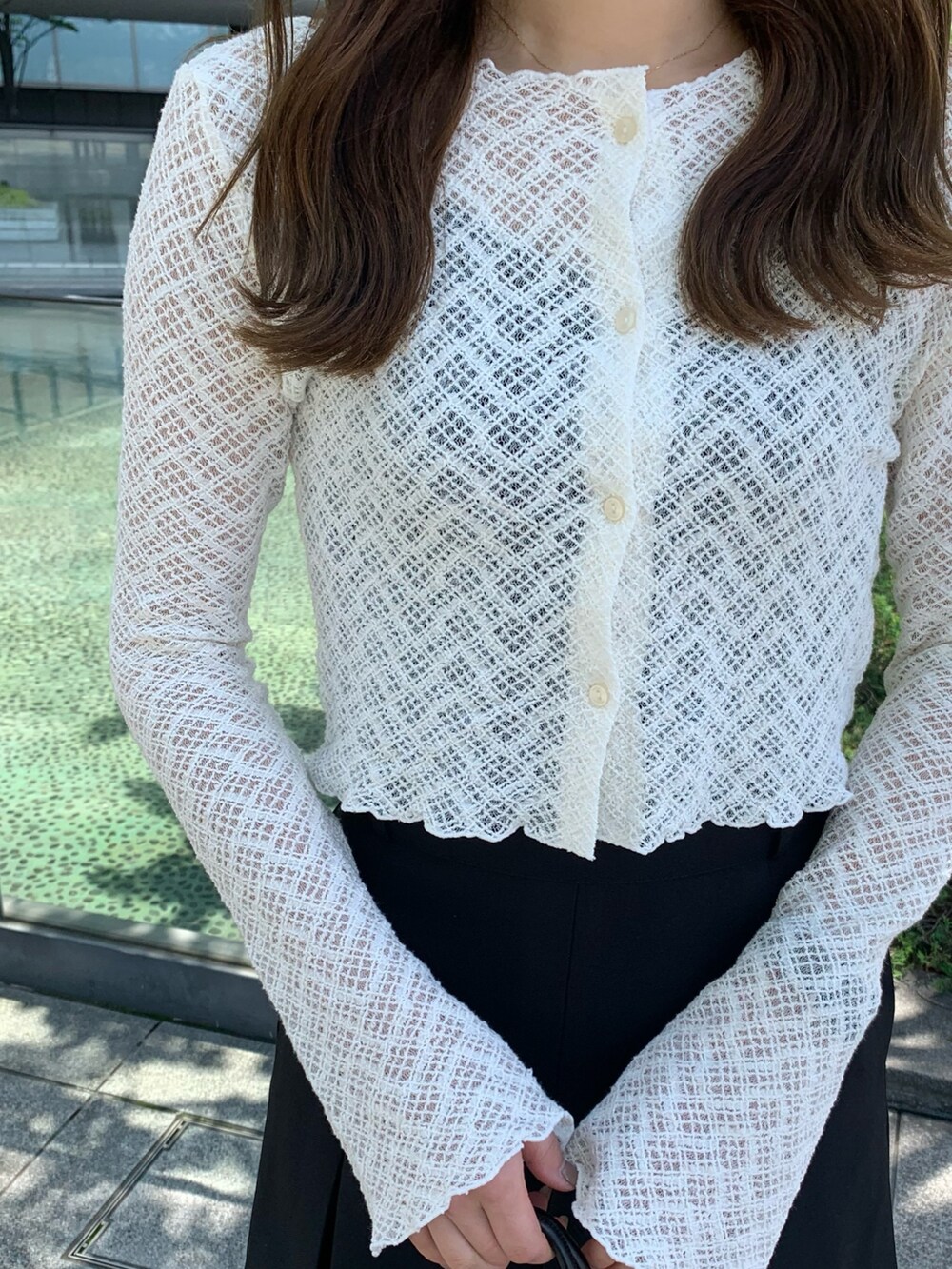 ブラック系のスカート、ブラック系のショルダーバッグを着用したレディースの夏コーディネートの4枚目の写真